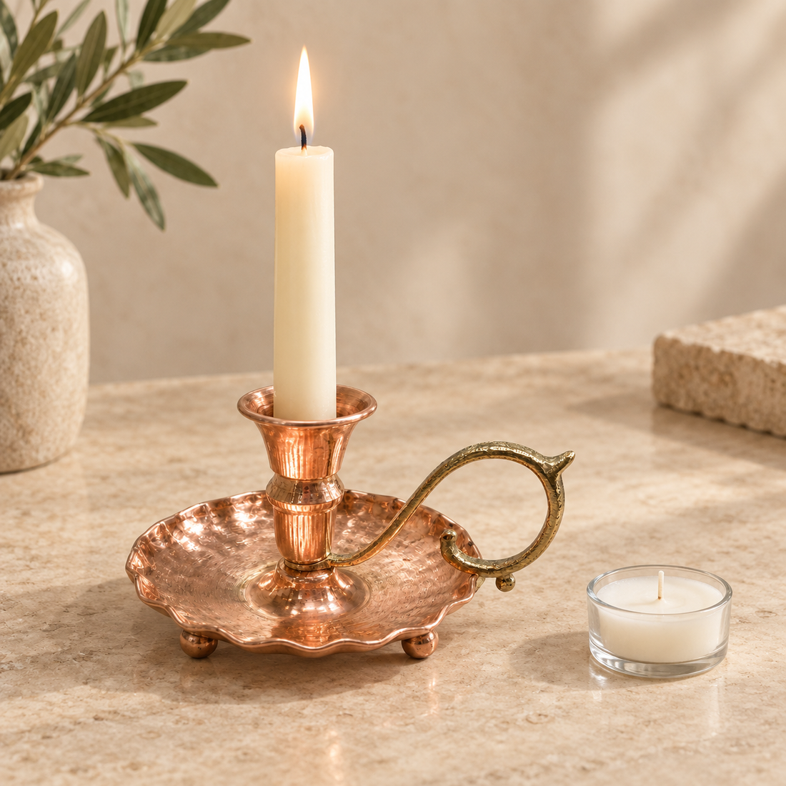 Bakır mumlukta yanan ince mum ve yanında farklı mum türünü gösteren tealight